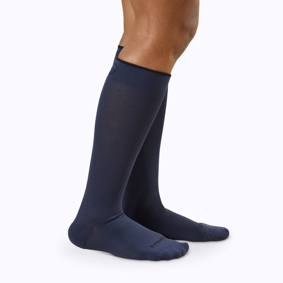 Side view of legs wearing knee high compression socks in navy