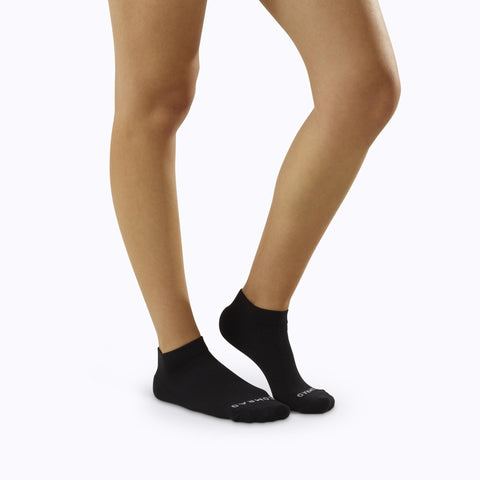 Side view of feet wearing nylon ankle compression socks in black solid