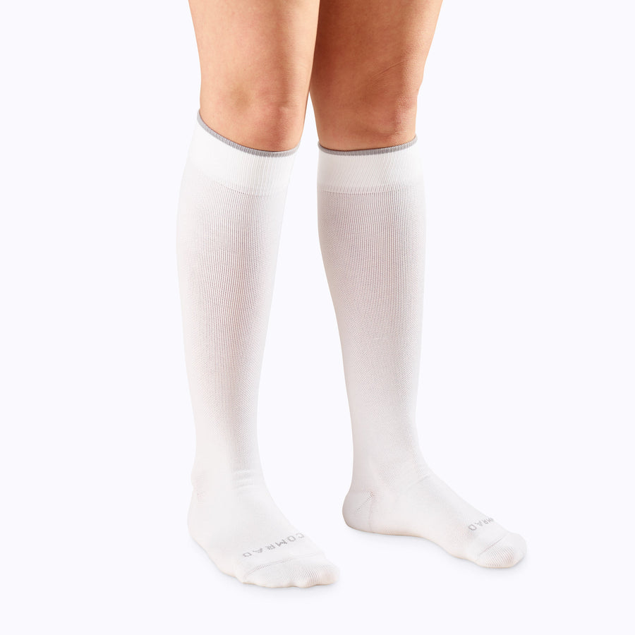 Front view of a pair of legs wearing nylon knee high compression socks in classic solid