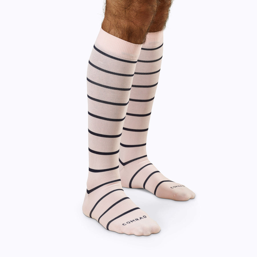 Side view of legs wearing  Knee-High Compression Socks in rose-navy stripes