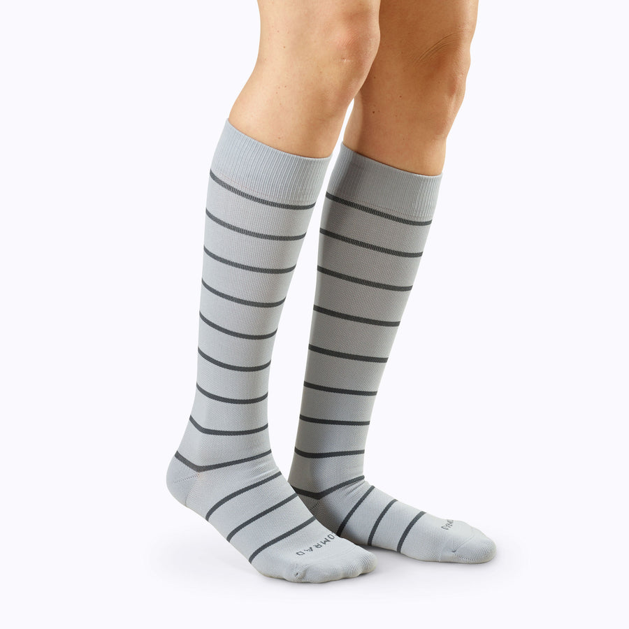 Side view of legs wearing  Knee-High Compression Socks in grey-charcoal stripes