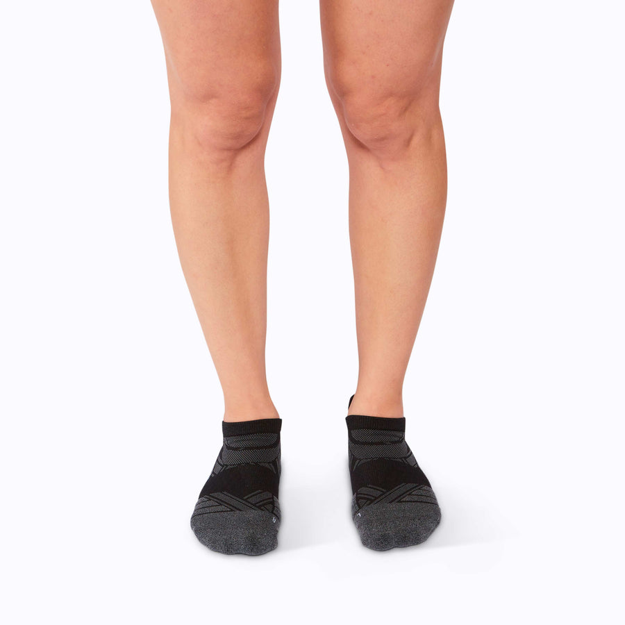 Front view of feet wearing a calf compression sleeve performance blend black solid