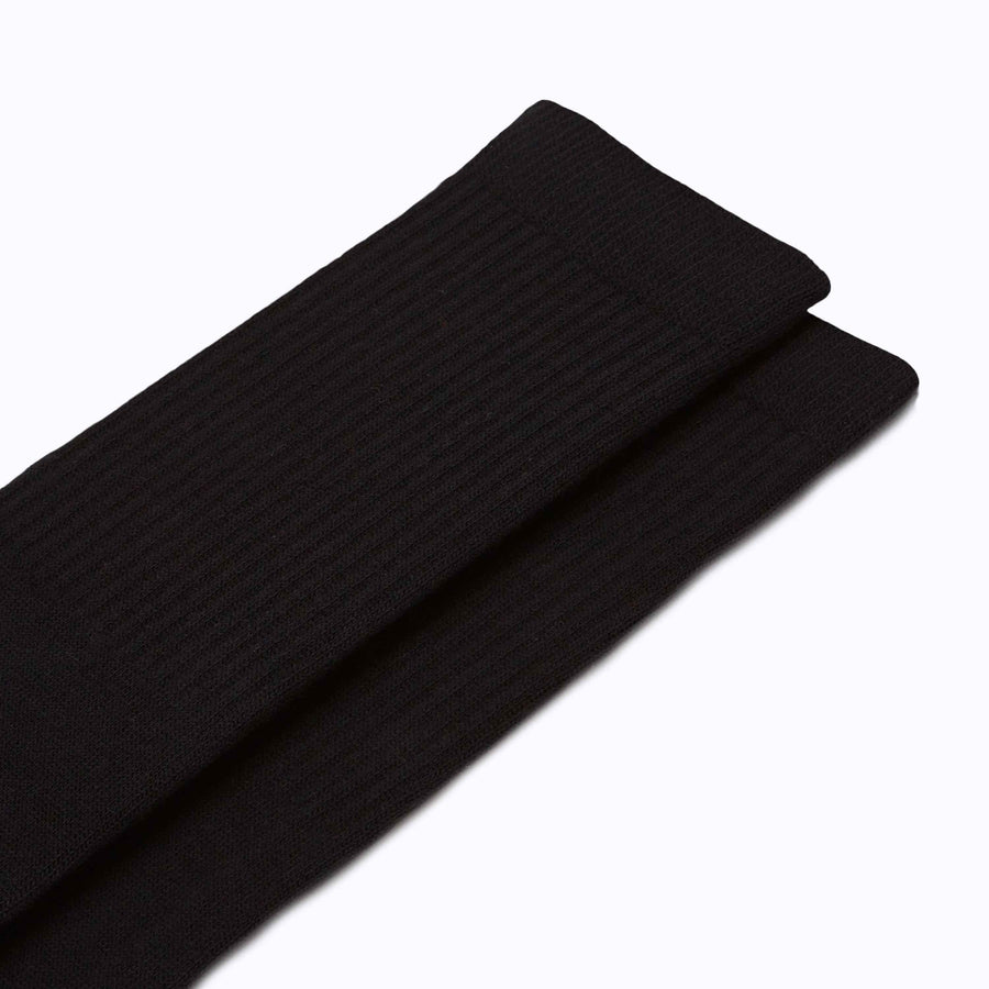 Close up view of a pair of combed-cotton crew socks in black solid