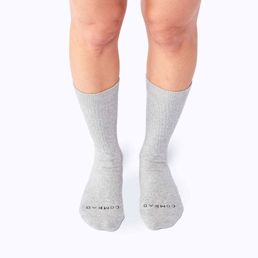 Front view of a pair of legs wearing the combed cotton crew socks in heather grey solid
