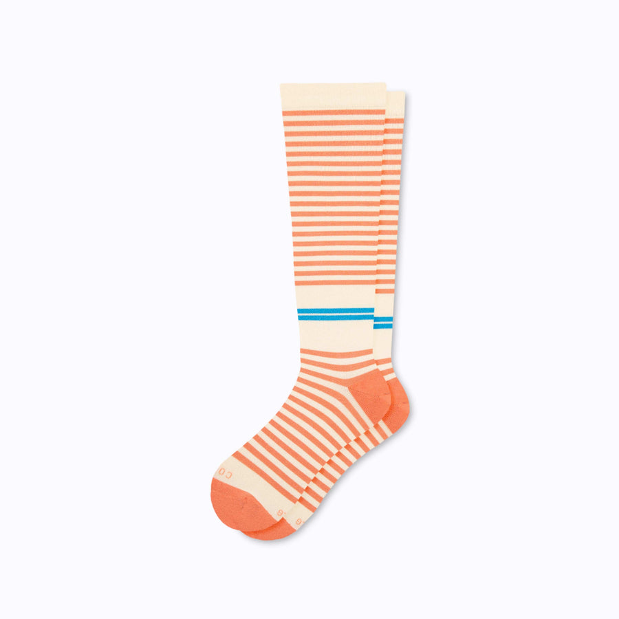 A pair of knee high cotton compression socks in cream-terra-cota tencel stripe