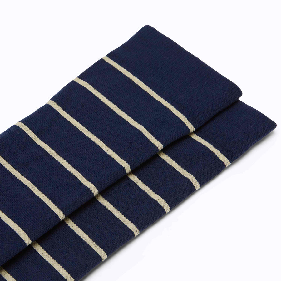 Close up view of knee high compression socks in navy-sand stripes