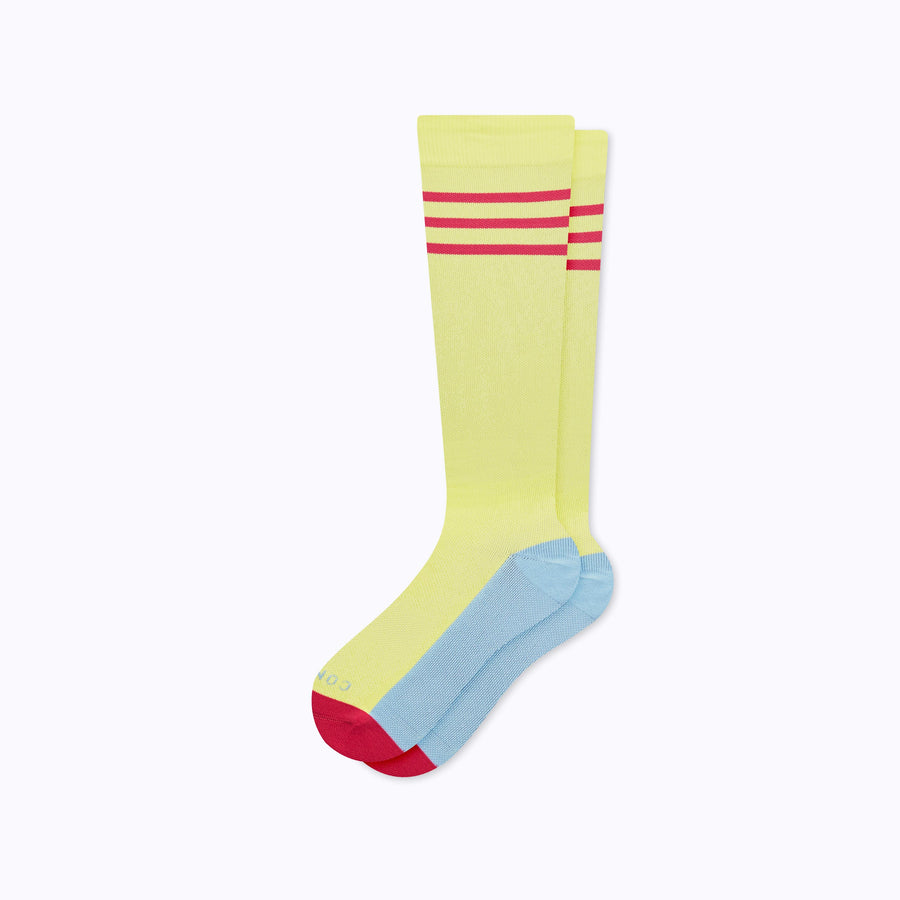 A pair of varsity style knee high compression socks in pear and berry