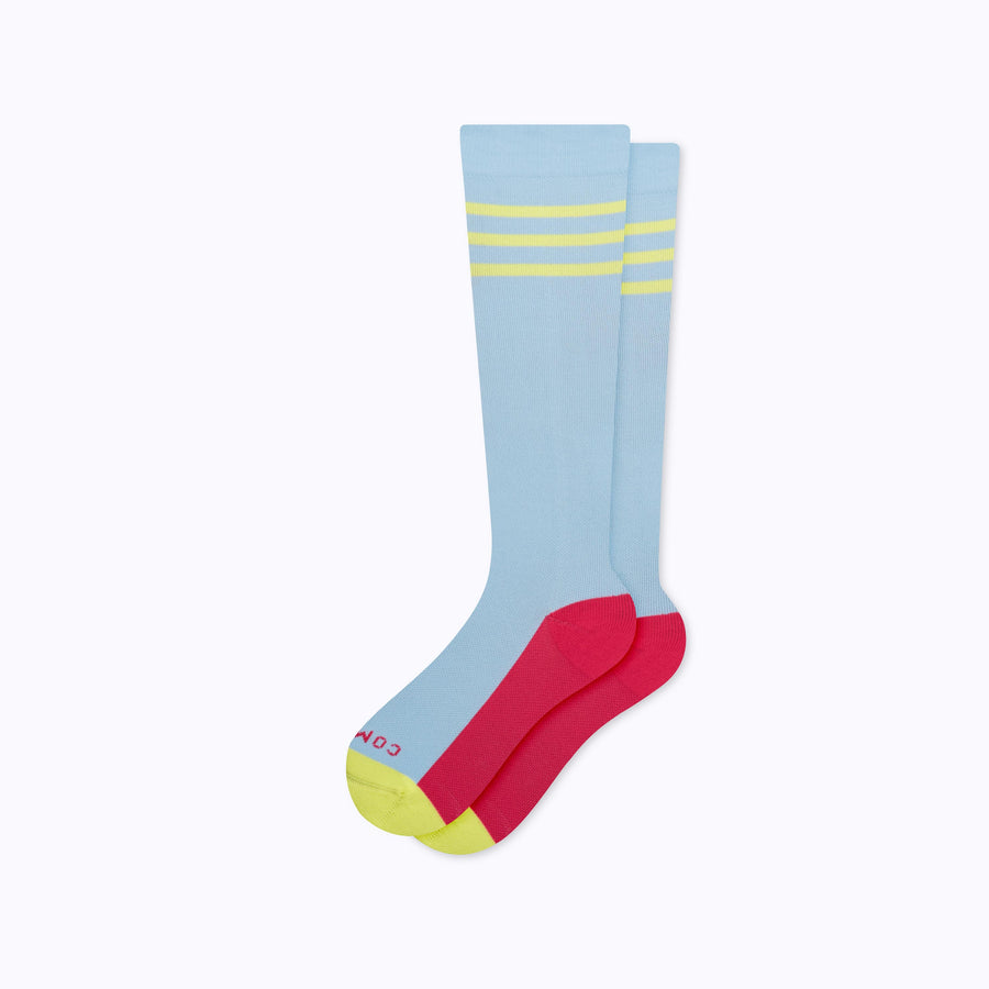 A pair of varsity style knee high compression socks in sky blue and pear