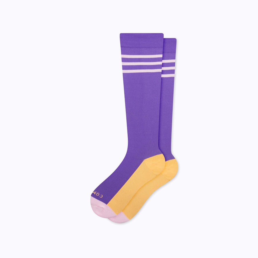 A pair of varsity style knee high compression socks in violet and bubblegum