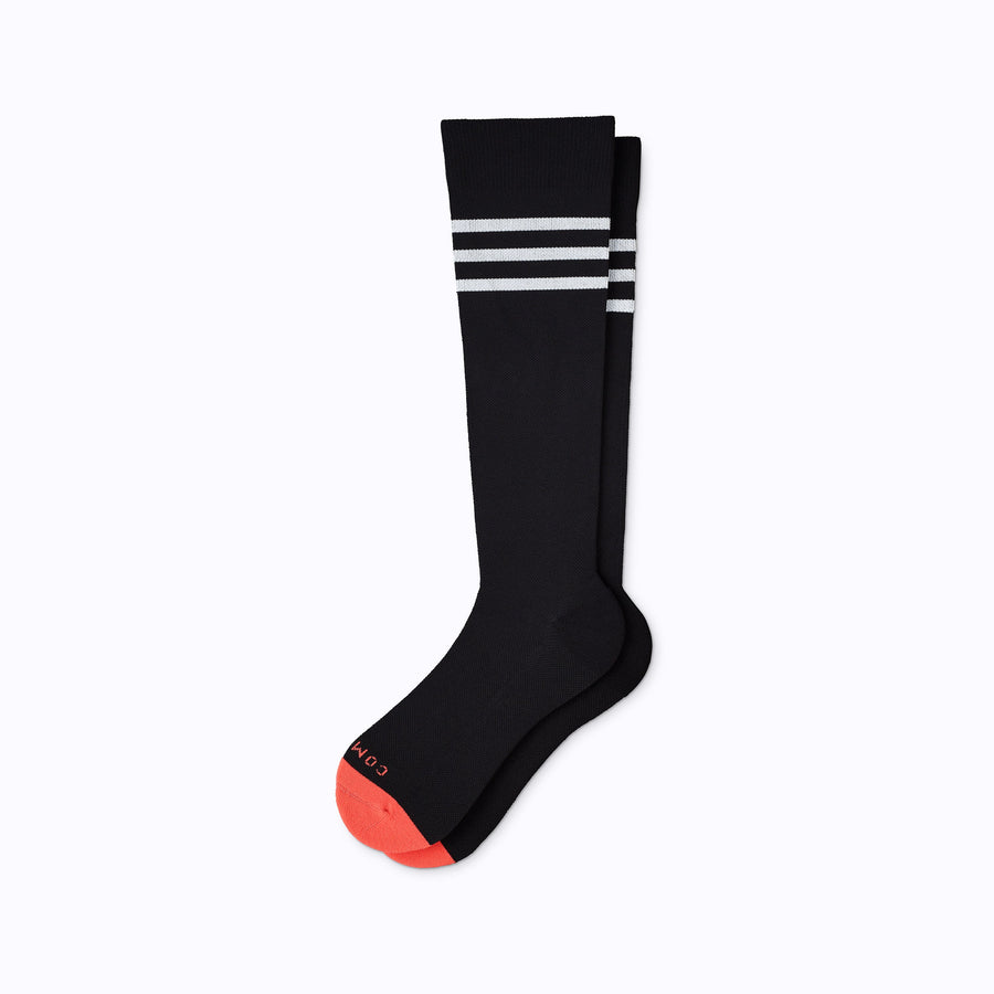 A pair of varsity style knee high compression socks in black and white